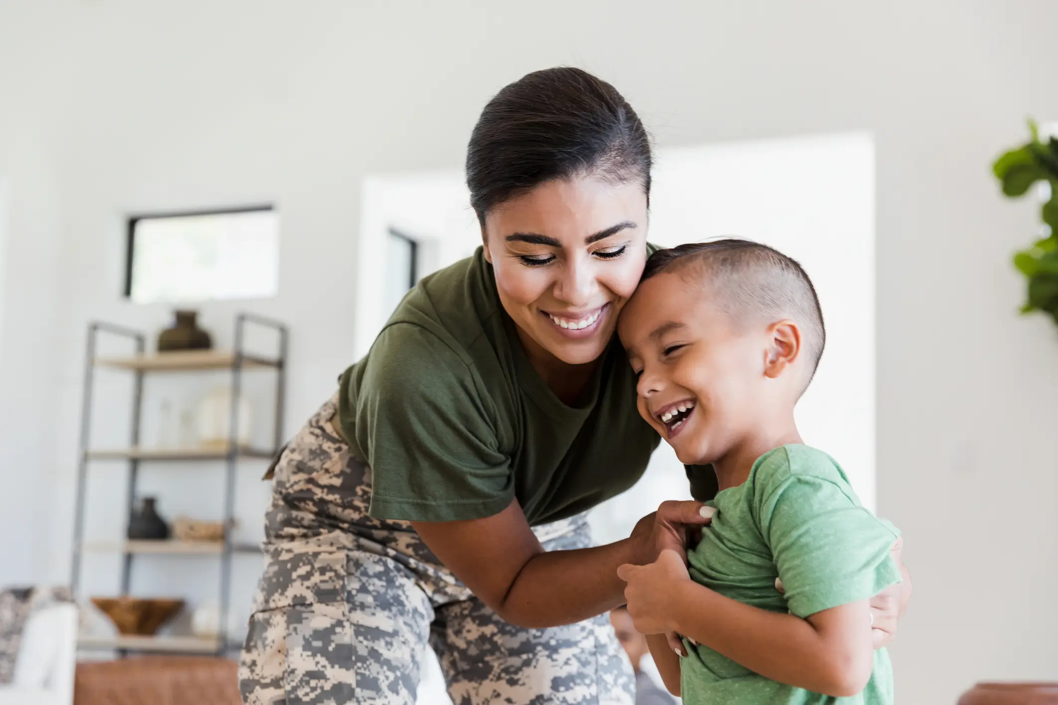 soldier mom playfully tickles elementary age son