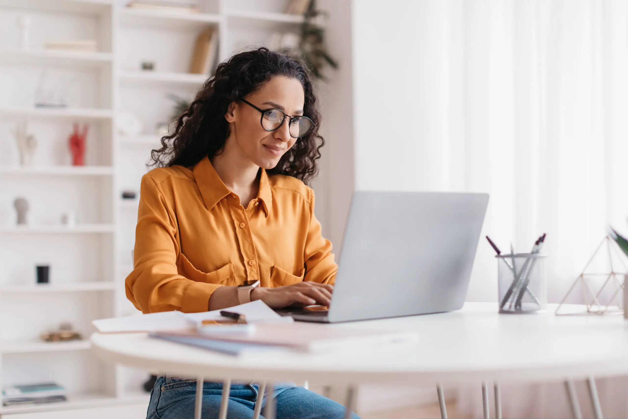 middle eastern lady using laptop working online sitting in office