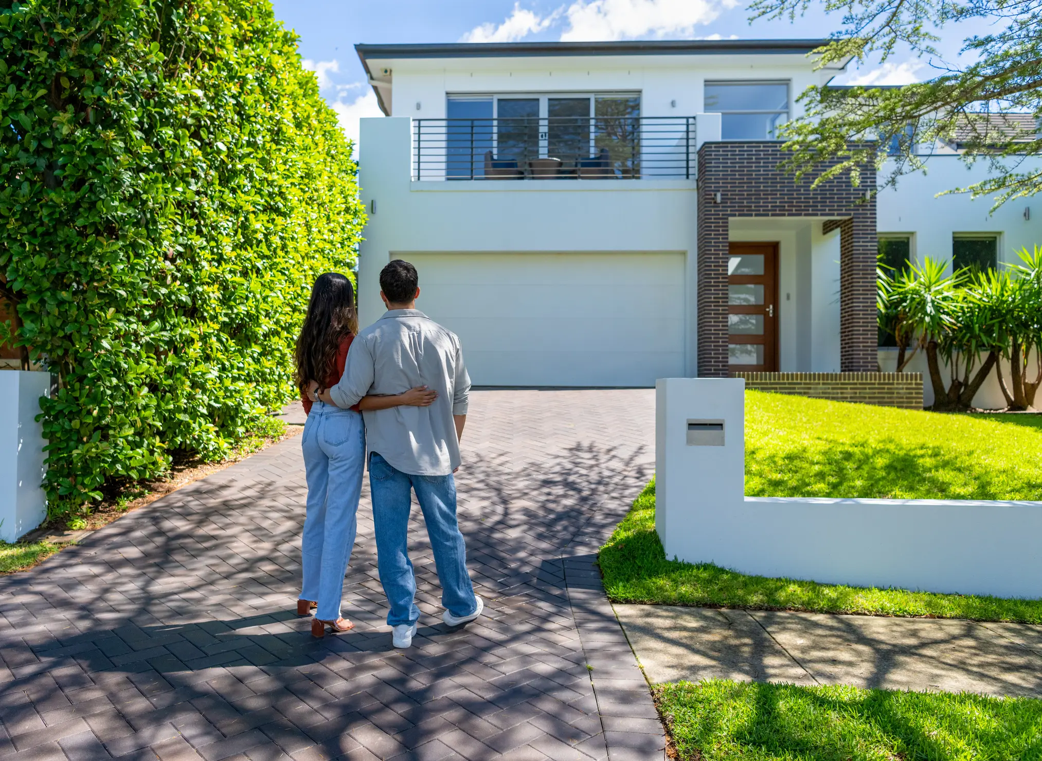 happy couple standing in front of their new home