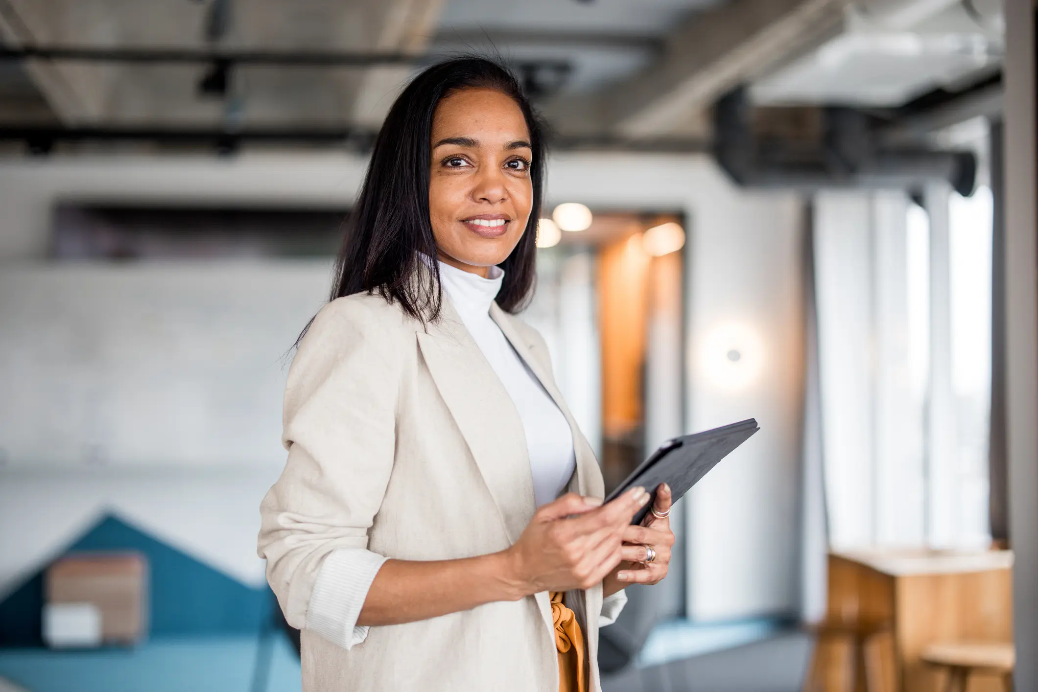 confident hispanic businesswoman with tablet
