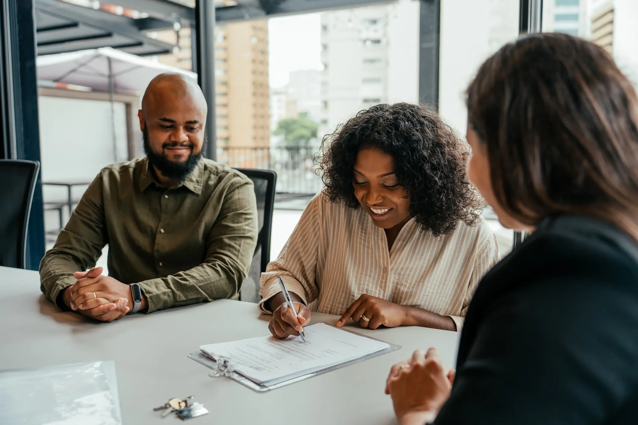 couple closing real estate contract with real estate agent