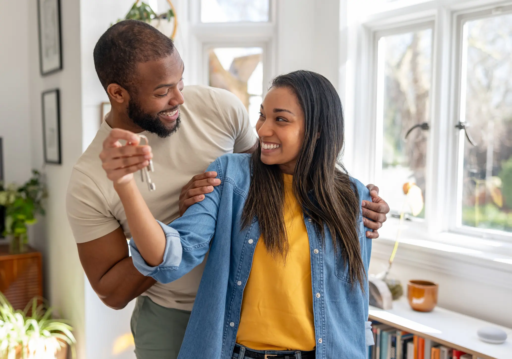 couple looking very happy holding the keys of their new house