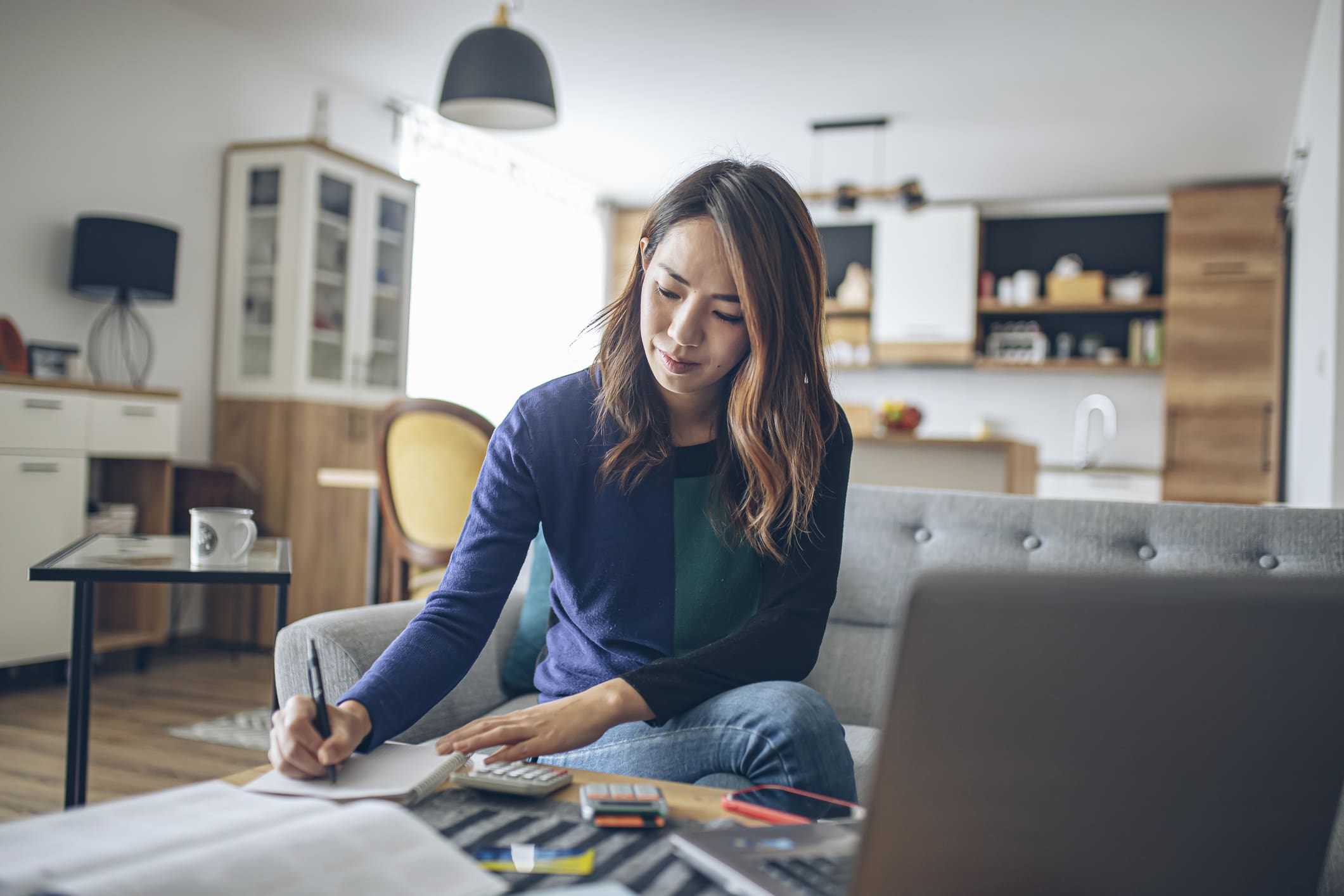 young japanese woman doing her finances at home