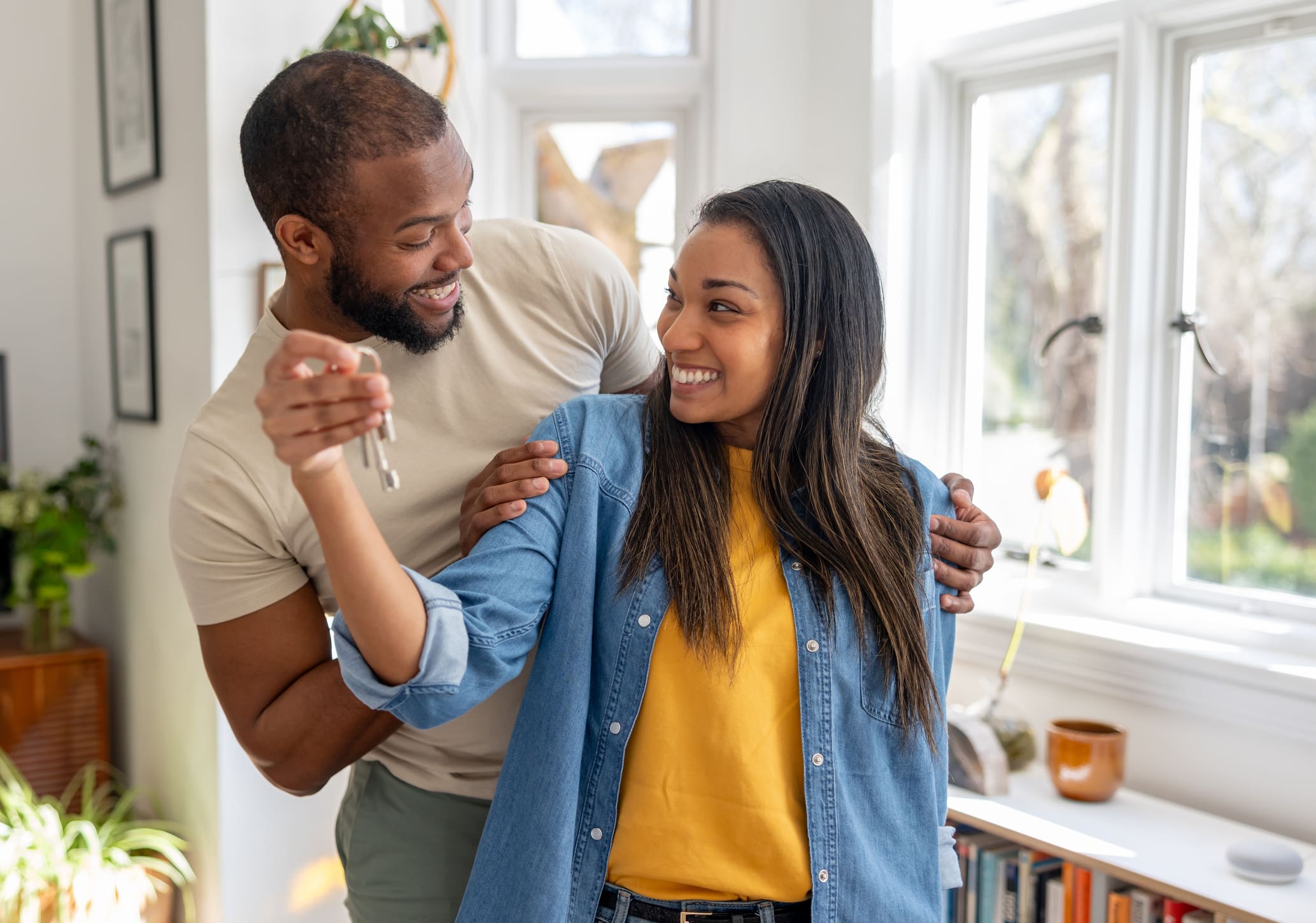 couple looking very happy holding the keys of their new house